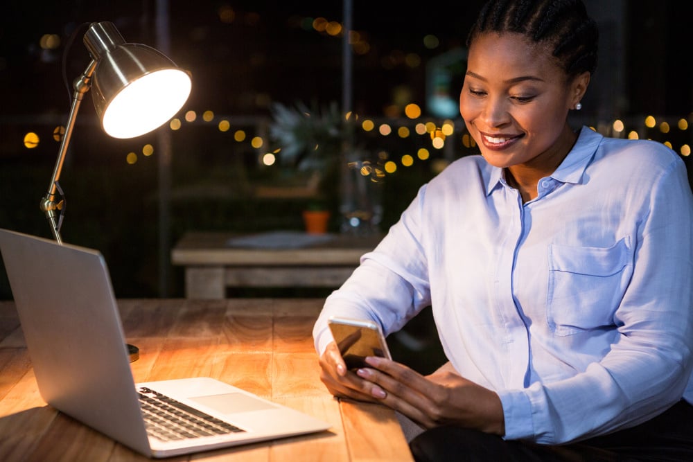 Businesswoman using mobile phone at her desk in the office