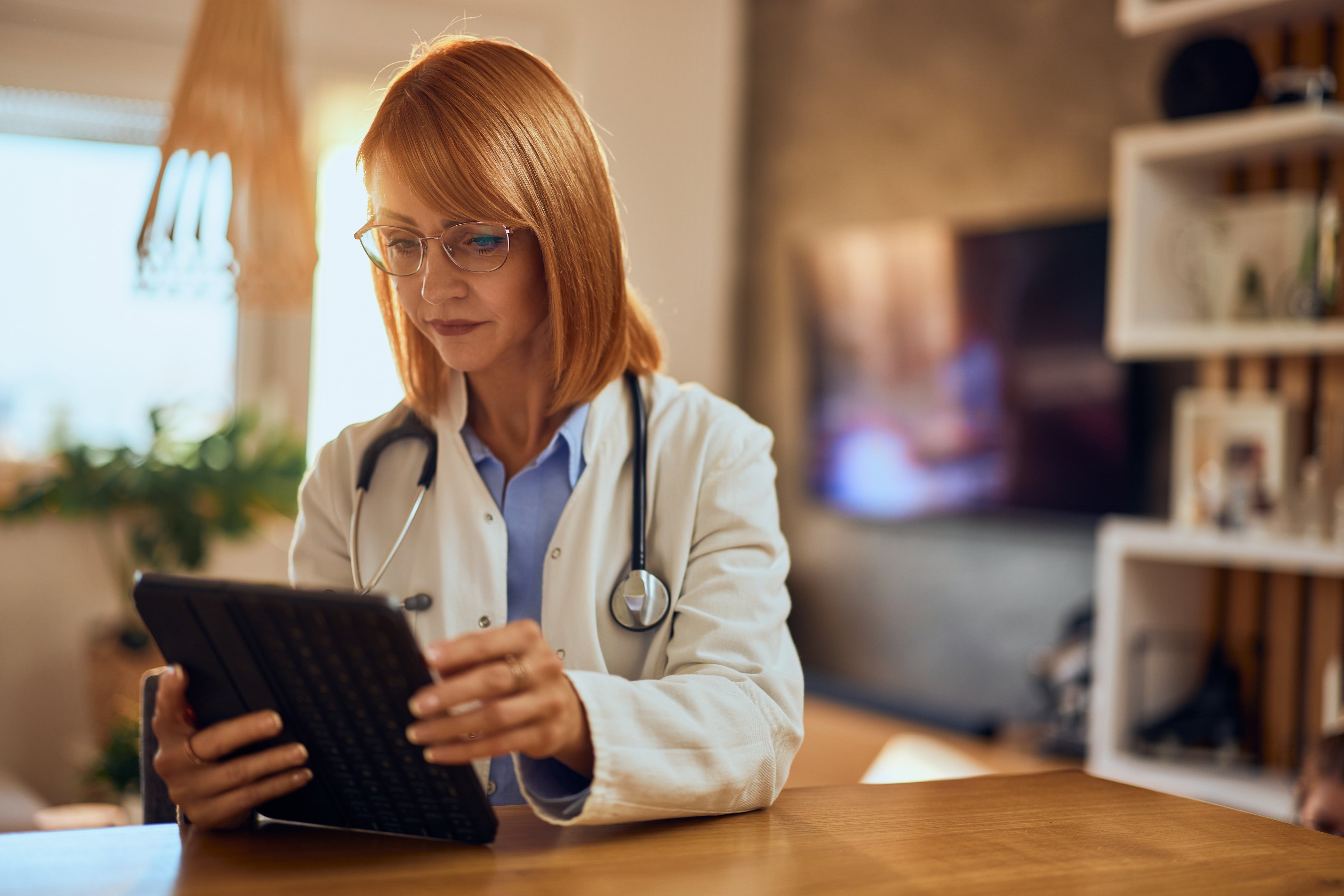 Doctor looking at tablet helping patient