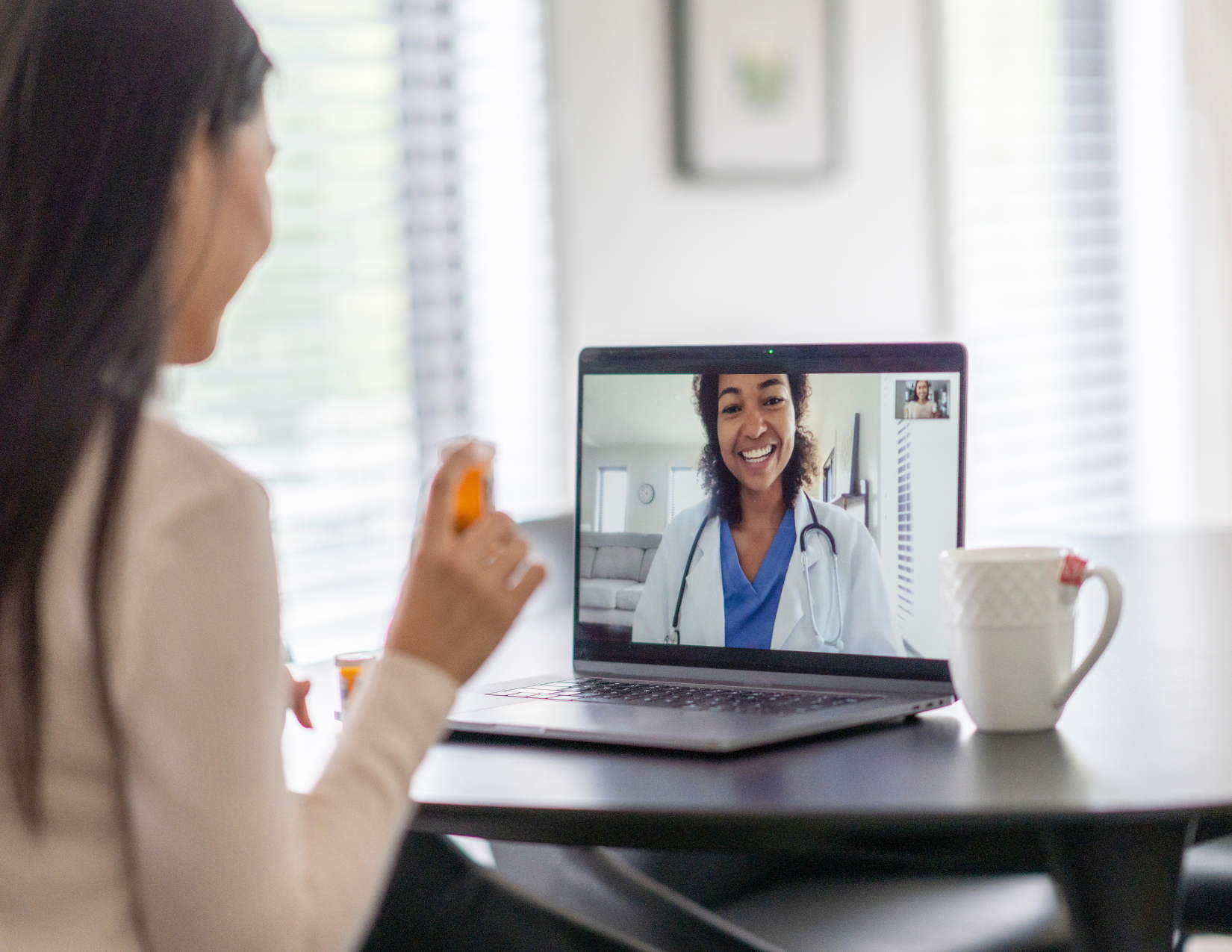 Woman talking to a female doctor on her laptop